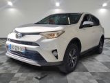 La Toyota RAV blanche est garée dans une grande pièce.