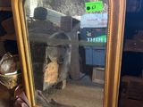 a mirror that is sitting on the ground next to a pile of junk