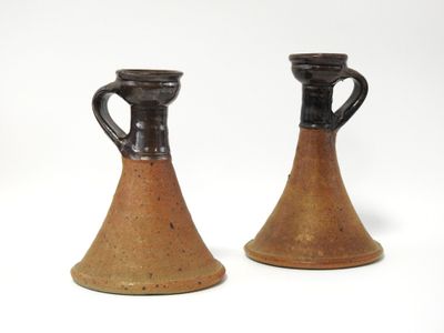 deux vases bruns posés l'un à côté de l'autre sur une surface blanche
