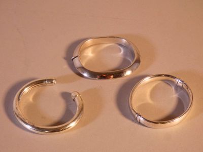 trois bagues en argent posées les unes à côté des autres sur une table