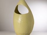 un vase jaune posé sur une table