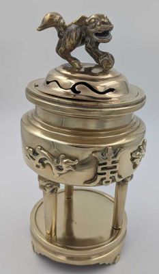 une figurine de chien en laiton ancien posée sur un socle