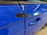 a blue car that has a sticker on the side of it