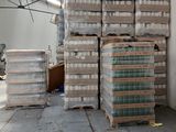 Des cartons d'eau sont empilés dans un vaste entrepôt