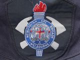 the badge on the back of a blue hat with a red flame on it