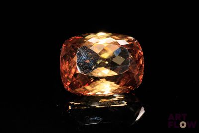 a close up of a large orange diamond on a black surface