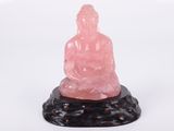 Statue de Bouddha en jade rose sur un socle en marbre noir, sur fond blanc