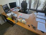 une photo d'un bureau sur lequel se trouvent deux ordinateurs et des papiers