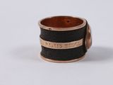 an image of a black and gold ring with a name engraved on it
