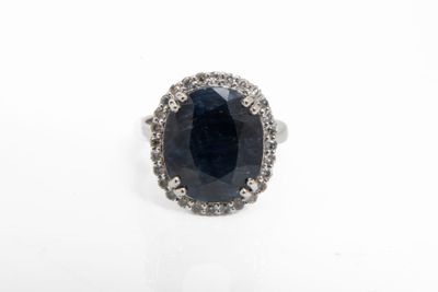 une bague ovale sertie d'un saphir et de diamants sur fond blanc