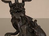 une statue en bronze représentant un taureau avec un sac sur le dos