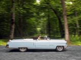 a man driving a car down the road in the woods