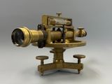 un télescope ancien en laiton muni d'un trépied et d'une lentille, posé sur un socle