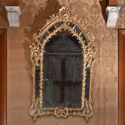 un miroir sur le mur au-dessus d'un lavabo dans une salle de bains