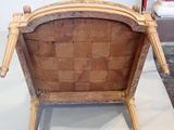 a wooden chair that has a woven seat on top of it