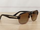 sunglasses on a wooden table with a white wall in the background