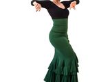the woman is wearing a green skirt and black top