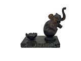une statue d'éléphant assis sur un socle en marbre