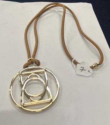 collier en argent et en or, orné d'un motif circulaire, monté sur un cordon marron