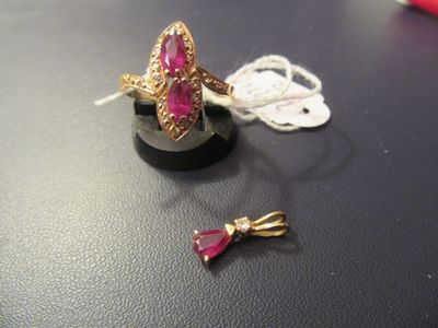 une bague ornée d'une pierre rose, à côté d'une paire de ciseaux