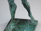 bronze statue of a man holding a tennis racquet in his right hand