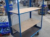 a blue cart with a shelf in the middle of a warehouse
