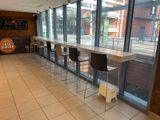 a long table with four chairs in front of a large window