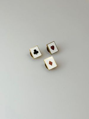 a pair of gold and black playing cards on a white surface