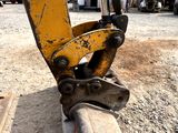 a close up view of a yellow excavator on the ground