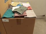 a cardboard box that has a bunch of clothes on top of it