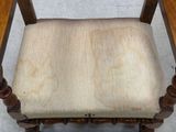 a wooden chair with a beige cushion on it