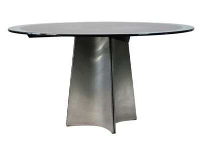 un gros plan d'une table avec un piètement en métal et un plateau en verre