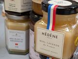 several jars of honey sit on a table with a ribbon around them
