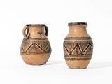 une paire de vieux vases en poterie ornés de motifs sur fond blanc