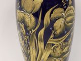 a blue vase with gold decoration on it on a white surface