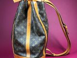 a louis vuitton bucket bag on a pink background
