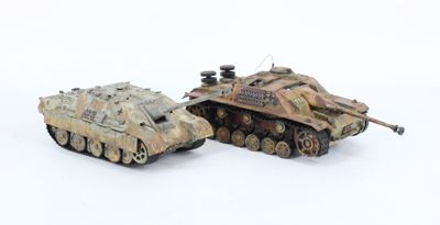 two toy tanks sitting next to each other on a white surface