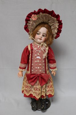 an old fashioned doll with a red dress and red hat