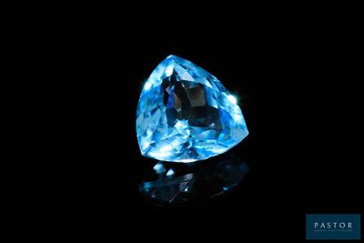 a close up of a blue diamond on a black surface