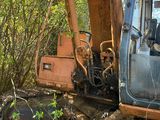 une pelleteuse bleue et orange qui est à l'arrêt dans la terre
