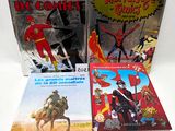 three books of comics are sitting on a white surface
