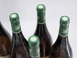 six bottles of wine are lined up on a table