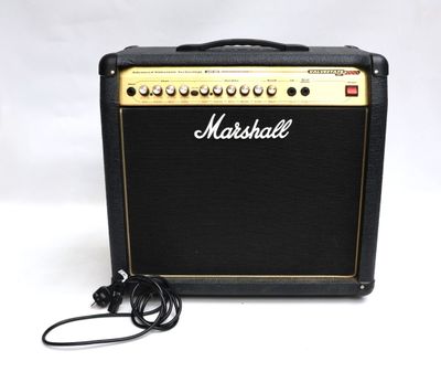 un amplificateur Marshall noir et doré posé sur un fond blanc