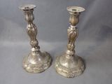 two silver candlesticks that are sitting on a table