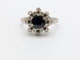 a close up of a black diamond ring on a white surface
