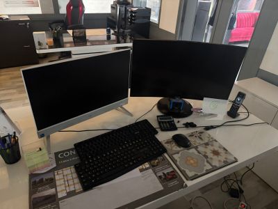two computer monitors sitting on a desk with a keyboard and mouse
