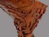 a wooden vase with carvings on it on a gray background