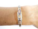 someone is wearing a bracelet with a blue and white design on it