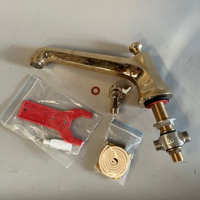 un robinet en laiton avec une poignée rouge et quelques autres objets
