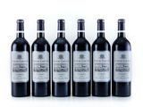 six bottles of wine are lined up in a row on a white surface